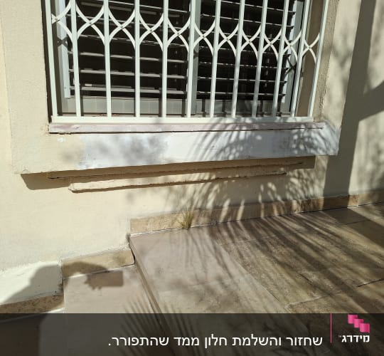 חלון עם סורגים מעל מדרגות אבן